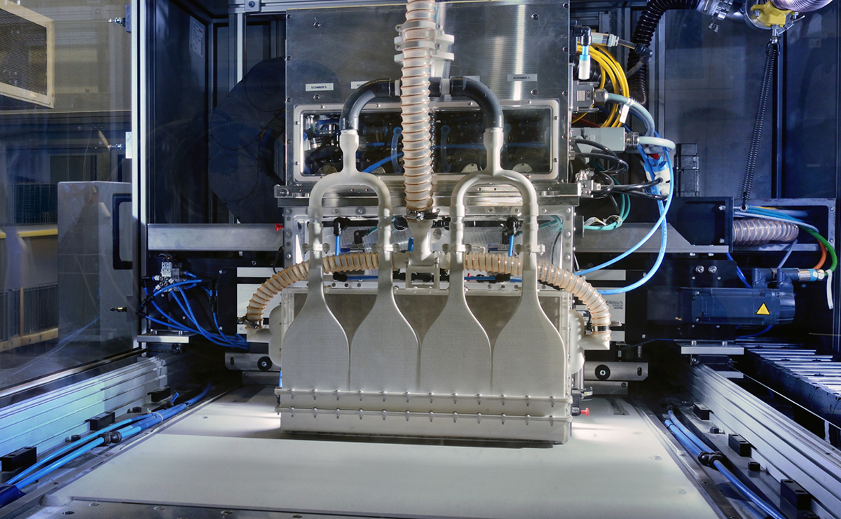How Can Additive Manufacturing Realize the Promise of Production Scale?