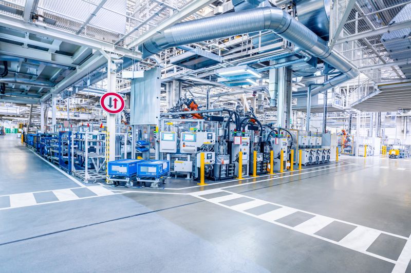 Robot arms and fixtured parts on a factory automation line feeding live events into automated production tracking